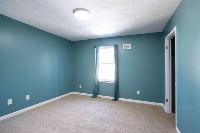 carpeted empty room with visible vents and baseboards