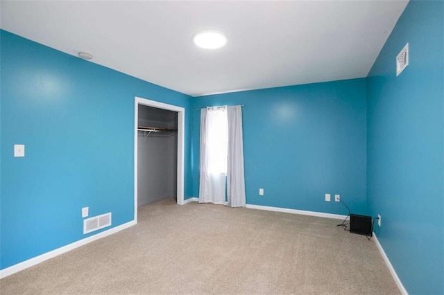 unfurnished bedroom featuring baseboards, a closet, visible vents, and carpet flooring