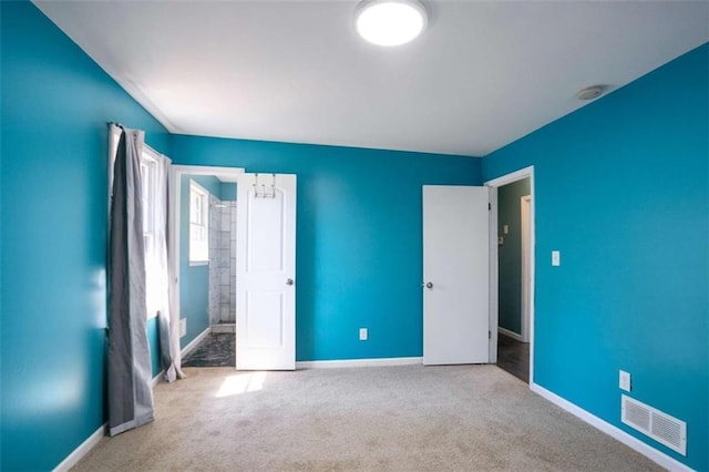 unfurnished bedroom with carpet floors, visible vents, and baseboards