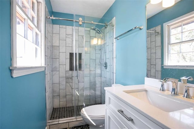 full bathroom featuring a stall shower, vanity, and toilet