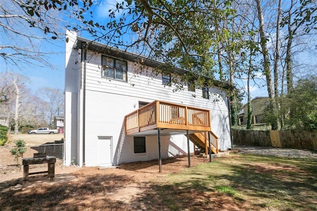 back of property with stairs, a deck, a chimney, and fence