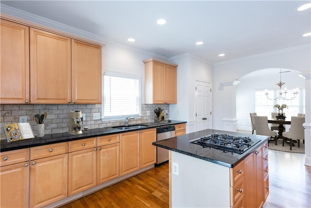 kitchen featuring sink, stainless steel appliances, a center island, light hardwood / wood-style floors, and decorative backsplash