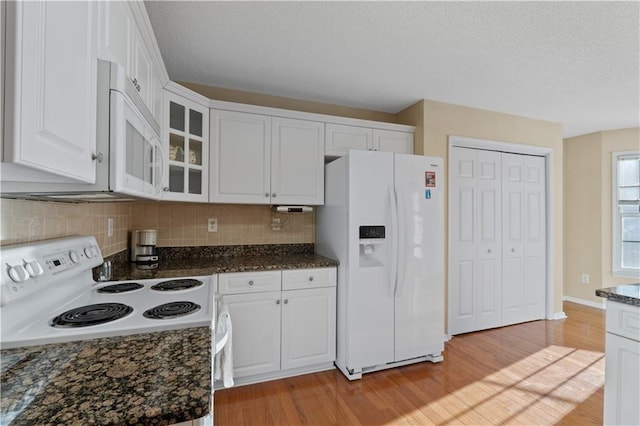 kitchen featuring glass insert cabinets, white appliances, and white cabinetry