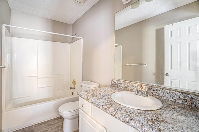 bathroom featuring vanity, toilet, shower / tub combination, and a textured ceiling