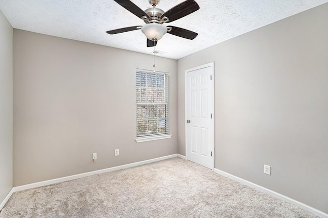 carpeted empty room with visible vents, baseboards, a textured ceiling, and ceiling fan