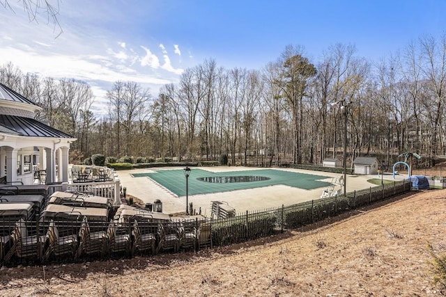 community pool with a patio area and fence