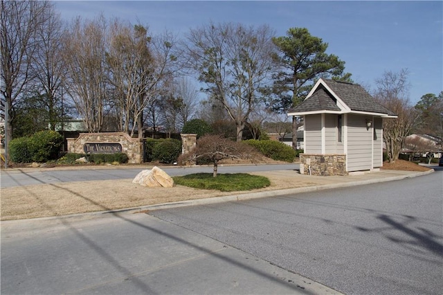 view of front of house with stone siding and roof with shingles