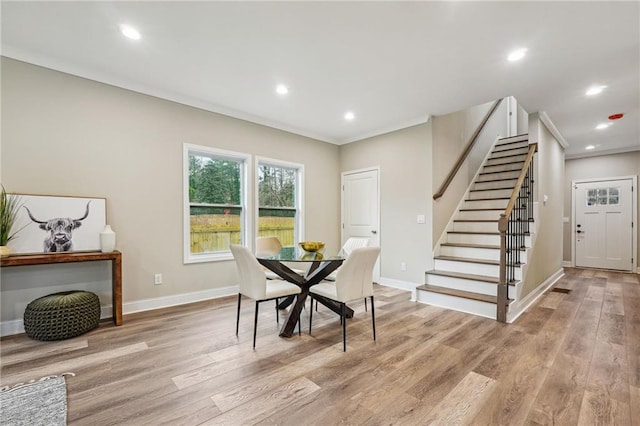 dining space with baseboards, stairway, light wood finished floors, and recessed lighting