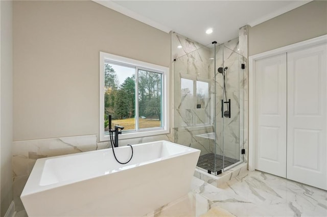 bathroom with tile walls, a freestanding bath, a marble finish shower, and marble finish floor