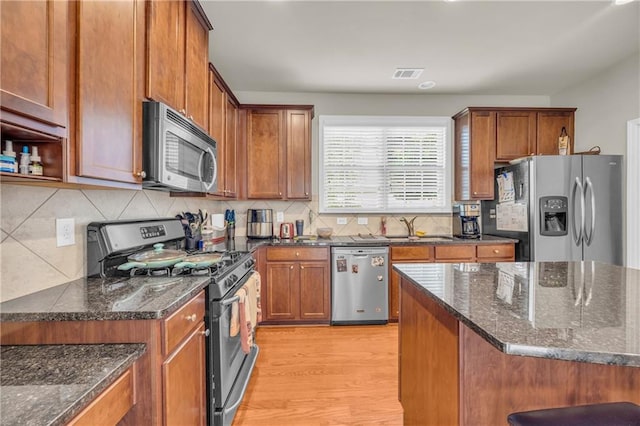 2677 Sardis Chase Ct, Buford, GA 30519 - kitchen featuring appliances with stainless steel finishes, light wood-type flooring, backsplash, and brown cabinetry