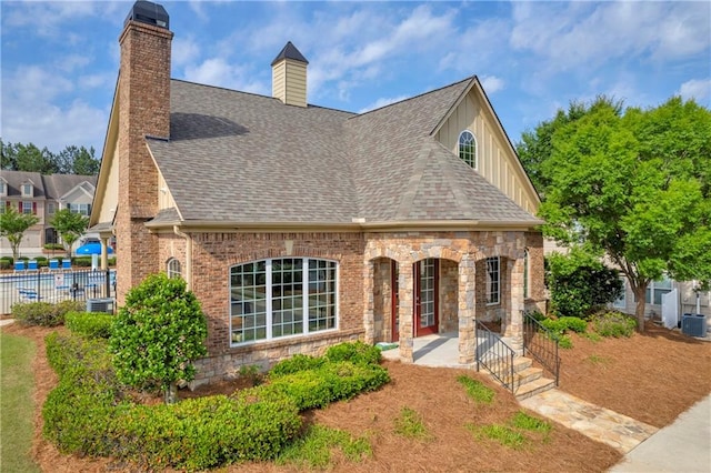 2677 Sardis Chase Ct, Buford, GA 30519 - view of front of property featuring board and batten siding, roof with shingles, a chimney, and central air condition unit