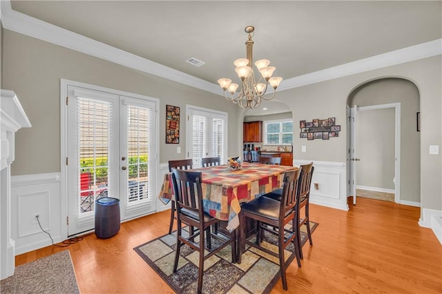 2677 Sardis Chase Ct, Buford, GA 30519 - dining area with arched walkways, ornamental molding, french doors, light wood-type flooring, and a chandelier