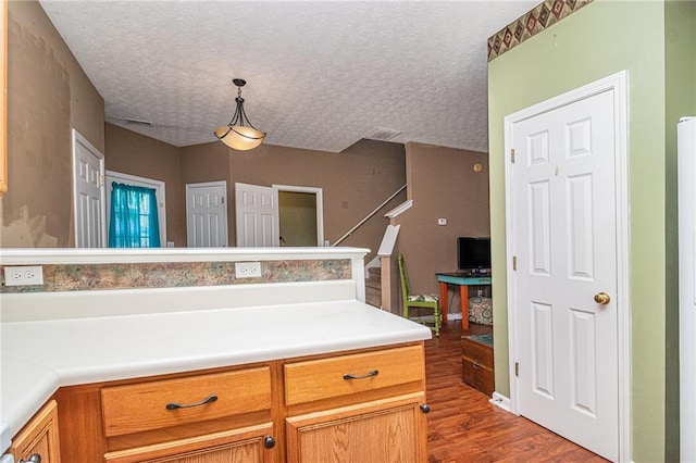 121 Ashgate Way, Carrollton, GA 30117 - kitchen with dark wood-style floors, a textured ceiling, light countertops, decorative light fixtures, and brown cabinetry