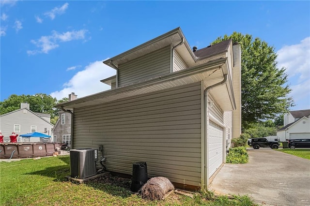 121 Ashgate Way, Carrollton, GA 30117 - view of side of home featuring central AC unit, a garage, concrete driveway, a lawn, and a chimney