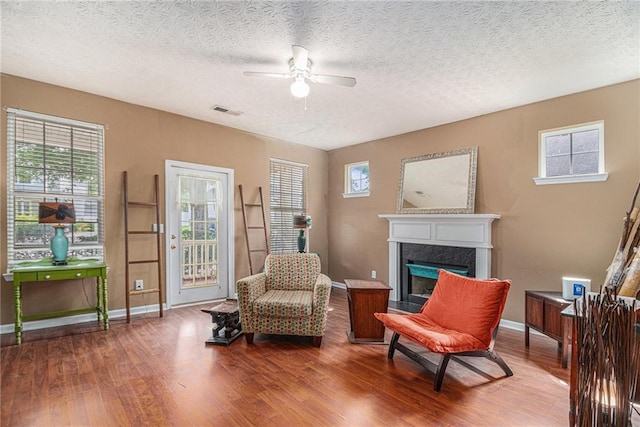 121 Ashgate Way, Carrollton, GA 30117 - sitting room featuring a ceiling fan, baseboards, wood finished floors, a premium fireplace, and a textured ceiling