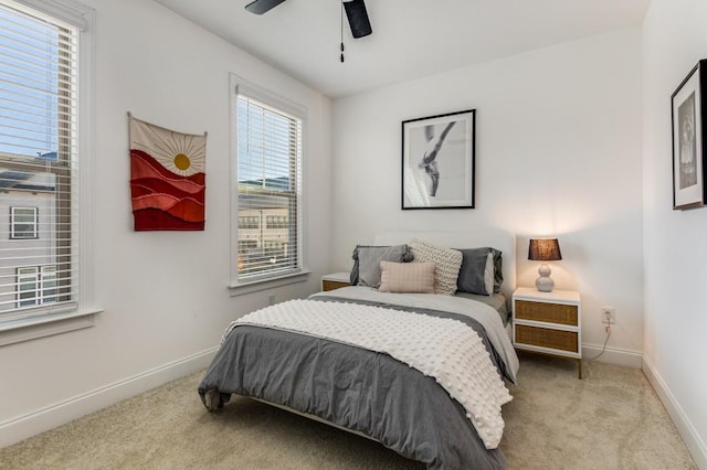 bedroom with light carpet, ceiling fan, and baseboards