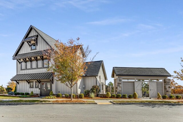 modern farmhouse with a standing seam roof, metal roof, a shingled roof, and board and batten siding