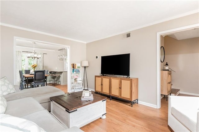 living room featuring wood-type flooring, a notable chandelier, and crown molding