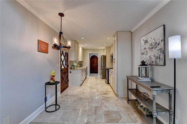 kitchen with stone tile floors, arched walkways, light stone counters, appliances with stainless steel finishes, and a sink