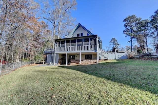 back of house with a sunroom, a fenced backyard, stairway, and a yard