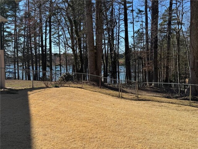 view of front of house featuring a shingled roof, concrete driveway, stone siding, an outdoor hangout area, and a water view