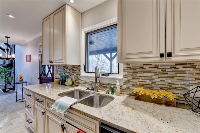 kitchen featuring light stone counters, crown molding, tasteful backsplash, stone finish floor, and a sink