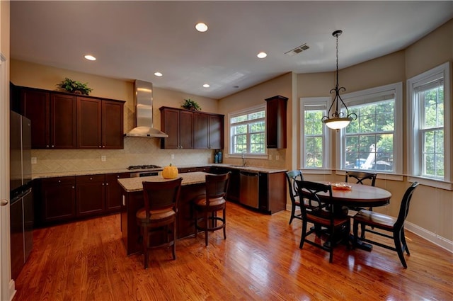 1622 Rivergreen Bnd SE Unit 26, Atlanta, GA 30339 - kitchen featuring wall chimney exhaust hood, dishwasher, a center island, tasteful backsplash, and light wood-style floors