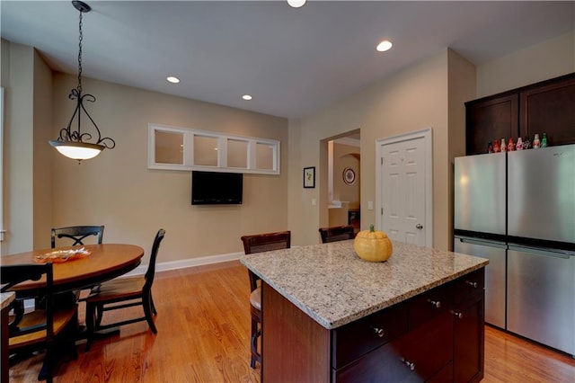 1622 Rivergreen Bnd SE Unit 26, Atlanta, GA 30339 - kitchen with freestanding refrigerator, a center island, a kitchen breakfast bar, light wood finished floors, and recessed lighting