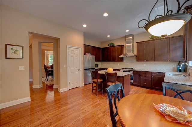1622 Rivergreen Bnd SE Unit 26, Atlanta, GA 30339 - kitchen with wall chimney range hood, appliances with stainless steel finishes, a kitchen island, tasteful backsplash, and light wood finished floors