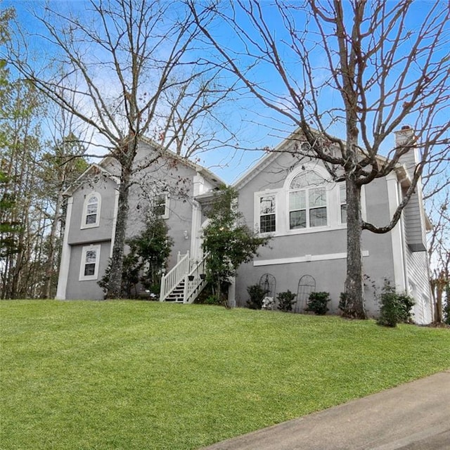 view of property exterior with a yard, a chimney, and stucco siding