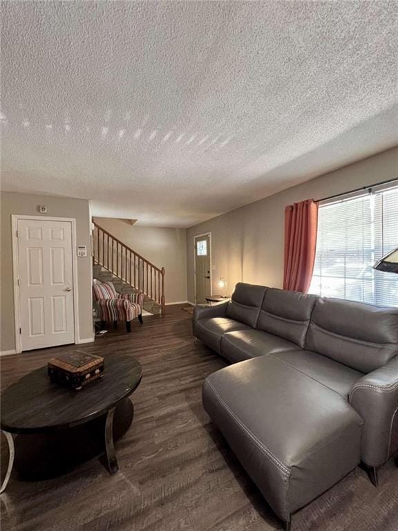 living room with dark wood-type flooring and a textured ceiling