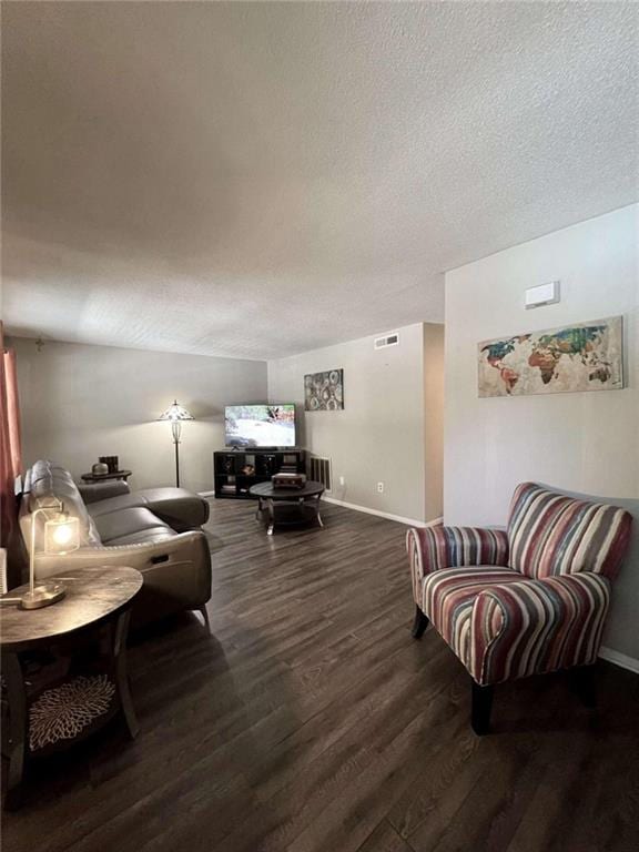 living room with dark hardwood / wood-style flooring and a textured ceiling