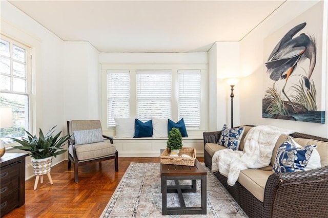 living room with a healthy amount of sunlight and dark parquet flooring