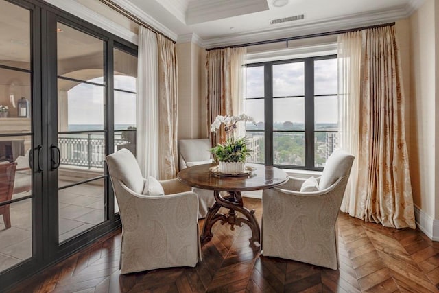 sitting room featuring crown molding, french doors, dark parquet floors, and a healthy amount of sunlight