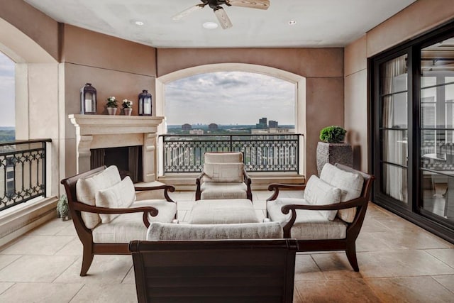 view of patio / terrace featuring ceiling fan and an outdoor living space with a fireplace