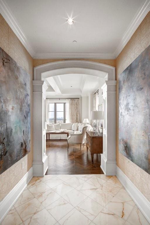 corridor with decorative columns, a raised ceiling, and crown molding