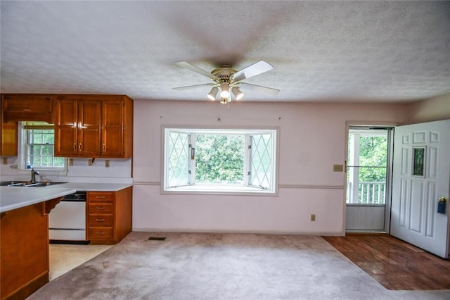 3223 Heritage Way, Buford, GA 30519 - kitchen with dishwasher, brown cabinetry, a sink, ceiling fan, and a textured ceiling