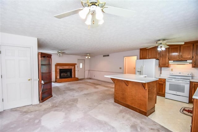 3223 Heritage Way, Buford, GA 30519 - kitchen featuring white appliances, under cabinet range hood, ceiling fan, brown cabinetry, and a textured ceiling