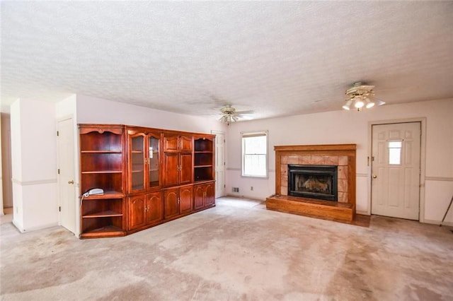 3223 Heritage Way, Buford, GA 30519 - unfurnished living room featuring ceiling fan, a tiled fireplace, carpet flooring, and a textured ceiling