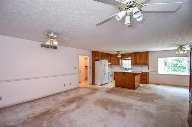 3223 Heritage Way, Buford, GA 30519 - kitchen with white appliances, brown cabinets, light countertops, a ceiling fan, and a textured ceiling