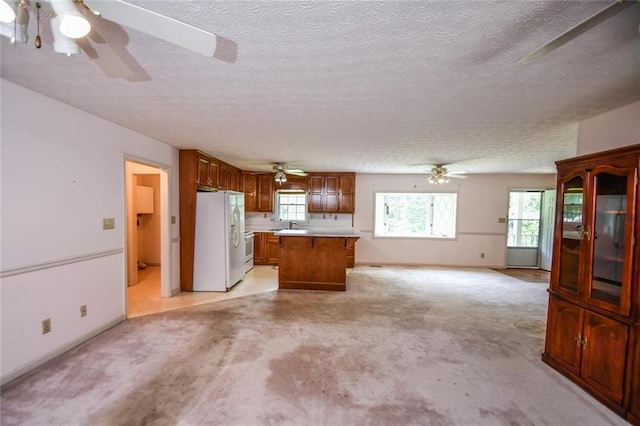 3223 Heritage Way, Buford, GA 30519 - kitchen featuring white refrigerator with ice dispenser, open floor plan, a textured ceiling, a ceiling fan, and light countertops