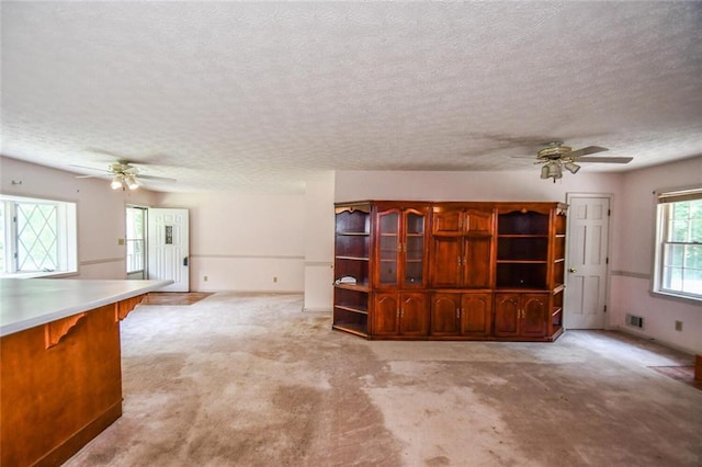 3223 Heritage Way, Buford, GA 30519 - unfurnished living room with ceiling fan, a textured ceiling, and light carpet