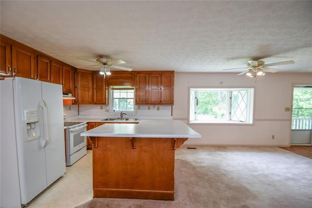 3223 Heritage Way, Buford, GA 30519 - kitchen with white appliances, a sink, a ceiling fan, under cabinet range hood, and light countertops