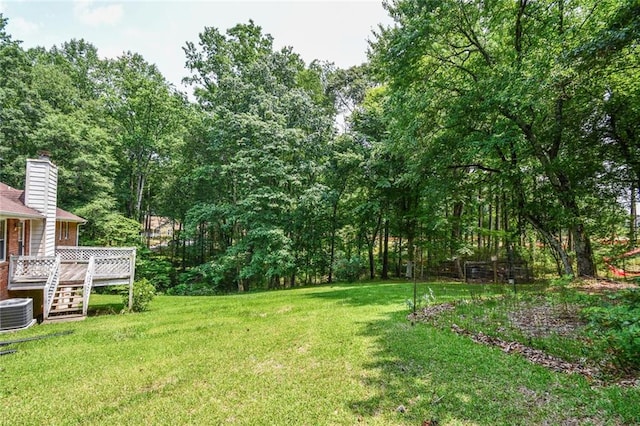 3223 Heritage Way, Buford, GA 30519 - view of grassy yard with a wooden deck and central air condition unit