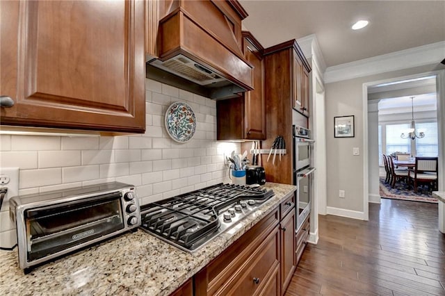 kitchen with decorative backsplash, light stone counters, custom exhaust hood, stainless steel appliances, and crown molding