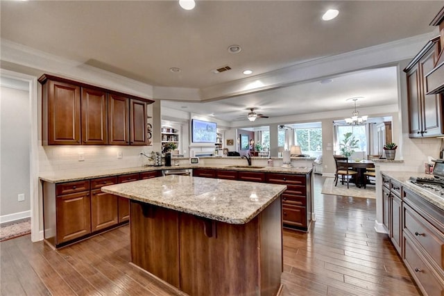 kitchen featuring dark wood-style flooring, a sink, a peninsula, and backsplash