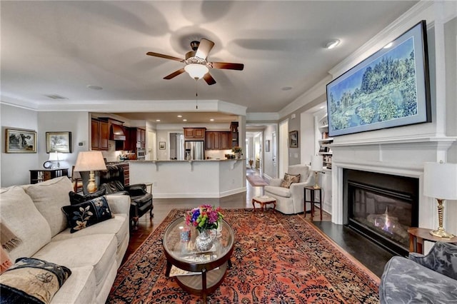 living area featuring a fireplace with flush hearth, baseboards, dark wood finished floors, and a ceiling fan