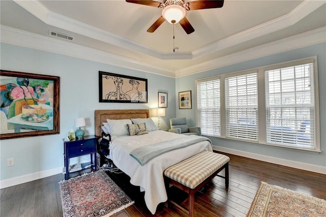 bedroom featuring baseboards, visible vents, a raised ceiling, dark wood-style floors, and crown molding