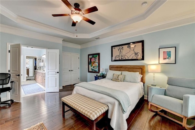 bedroom featuring a tray ceiling, dark wood finished floors, and crown molding