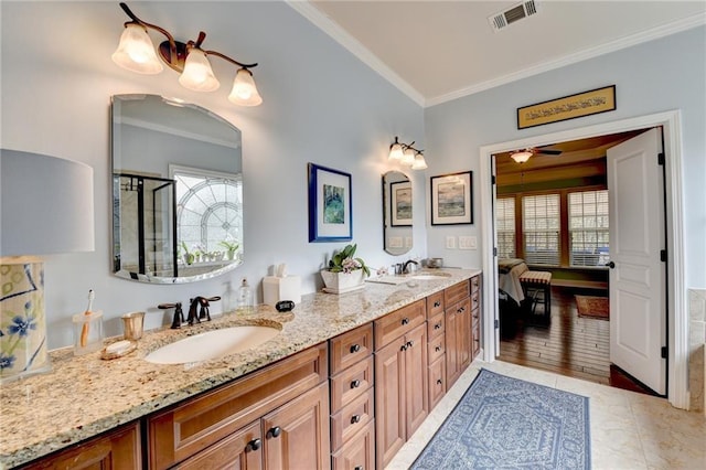 ensuite bathroom with double vanity, ornamental molding, a sink, and visible vents